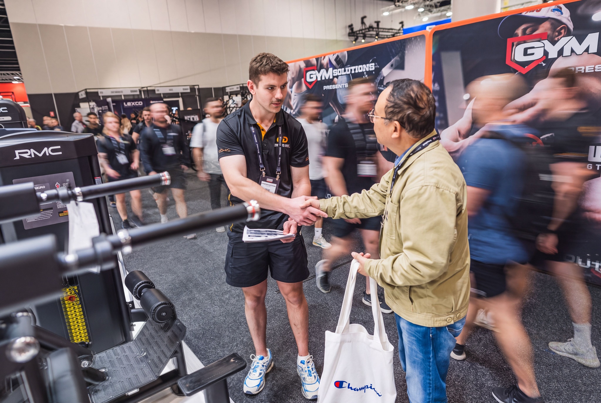 Exhibitor shaking hands with a visitor at a gym equipment stand during AusFitness Expo