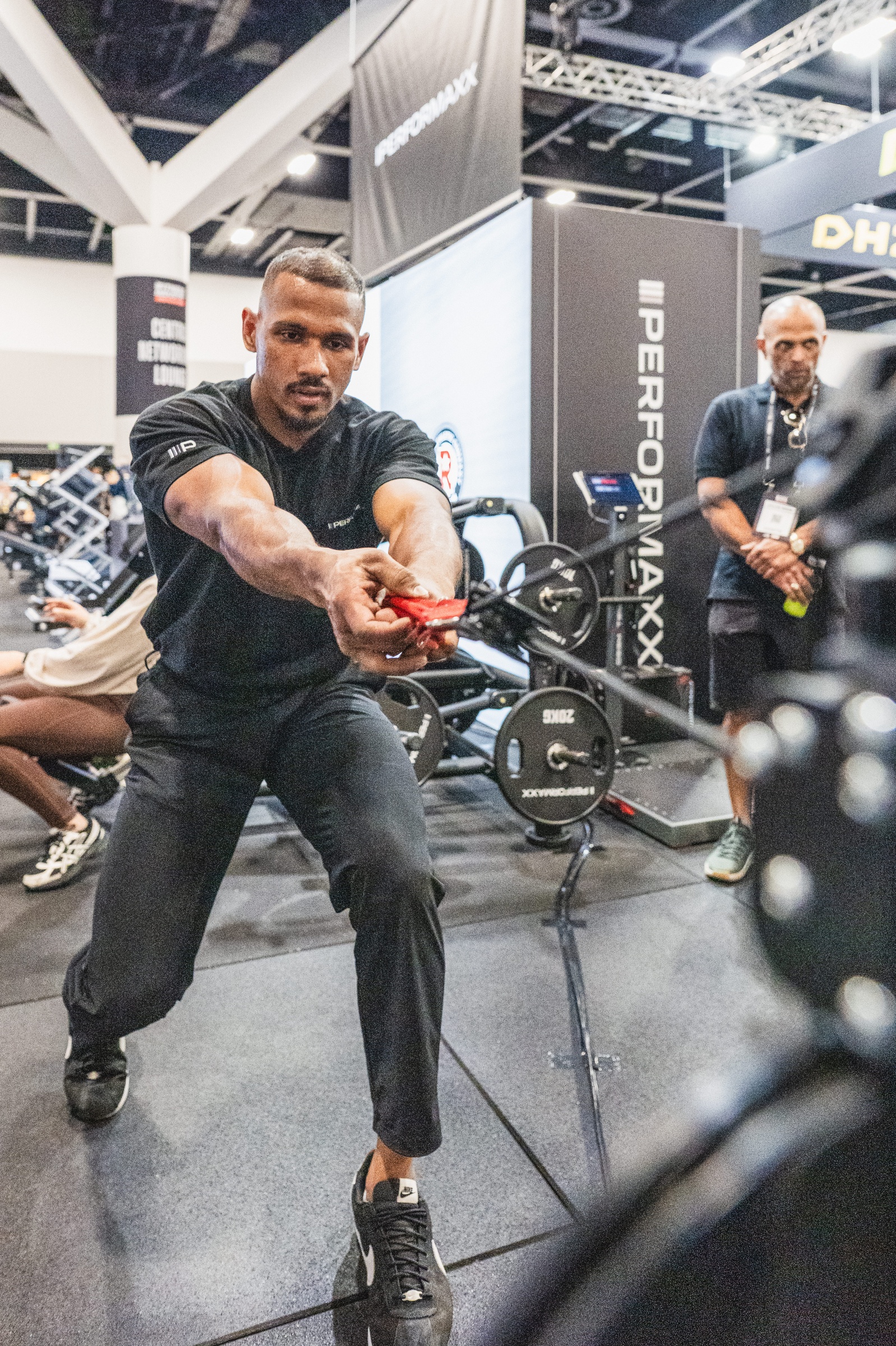 Athlete demonstrating a cable machine exercise at a fitness brand stand, AusFitness Expo